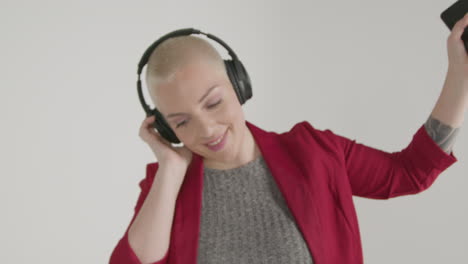 female model wearing blazer listening to headphones and dancing 01