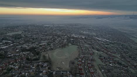 4k hazey cinematic aerial footage, depicting a harsh english winter cold spell with mist and freezing temperatures