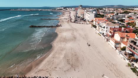 Riders-riding-horses-in-Palavas-les-Flots,-on-the-Mediterranean-coast-of-France-on-a-sunny-day,-aerial-view-with-a-drone