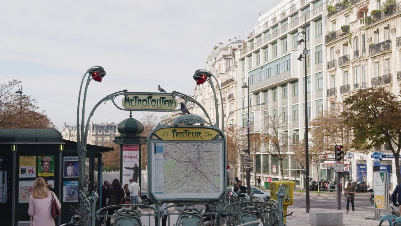 Street view of people walking by Pasteur metro station in Paris, France
