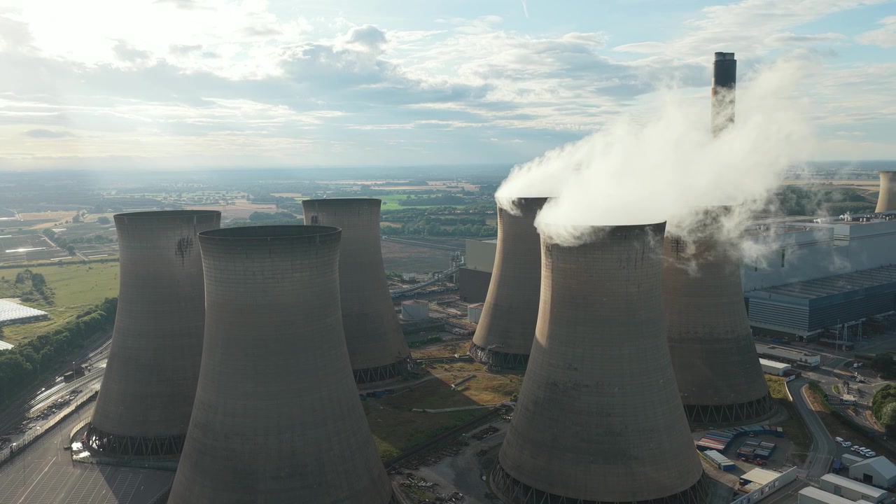 Il vapore sale dalle imponenti torri di raffreddamento della centrale elettrica di Drax nel North Yorkshire durante una limpida giornata estiva, mentre l'impianto genera elettricità per la regione circostante dell'Inghilterra