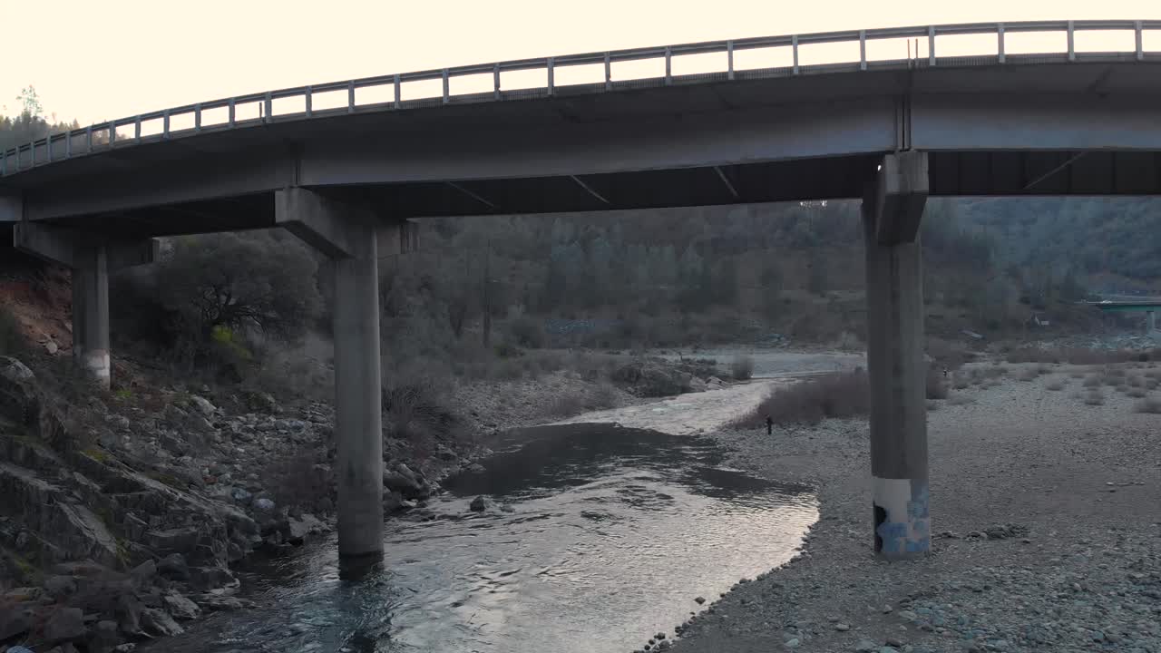 올드 포레스트힐 로드 브릿지 (old forest hill road bridge) 는 캘리포니아의 아메리칸 리버 (american river) 에 있는 오번 수영구 (auburn swimming hole) 를 가로지르고 있으며, 초록색 나무와 산으로 둘러싸여 있다.