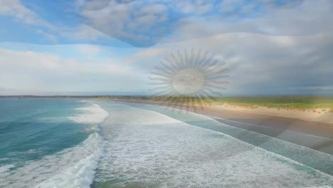 Digital-composition-of-waving-argentina-flag-against-aerial-view-of-the-beach-and-sea-waves