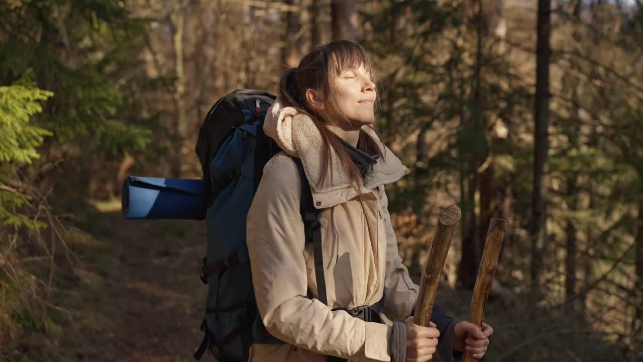 Woman hiking in a forest with a backpack enjoying nature