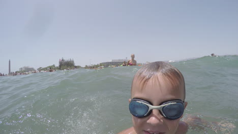 niño alegre bañándose y buceando en el mar