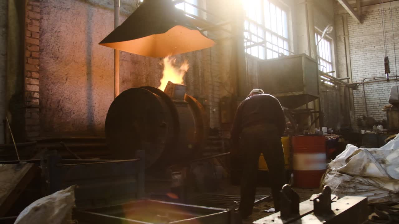 металлург, работающий на плавильной печи на промышленном заводе