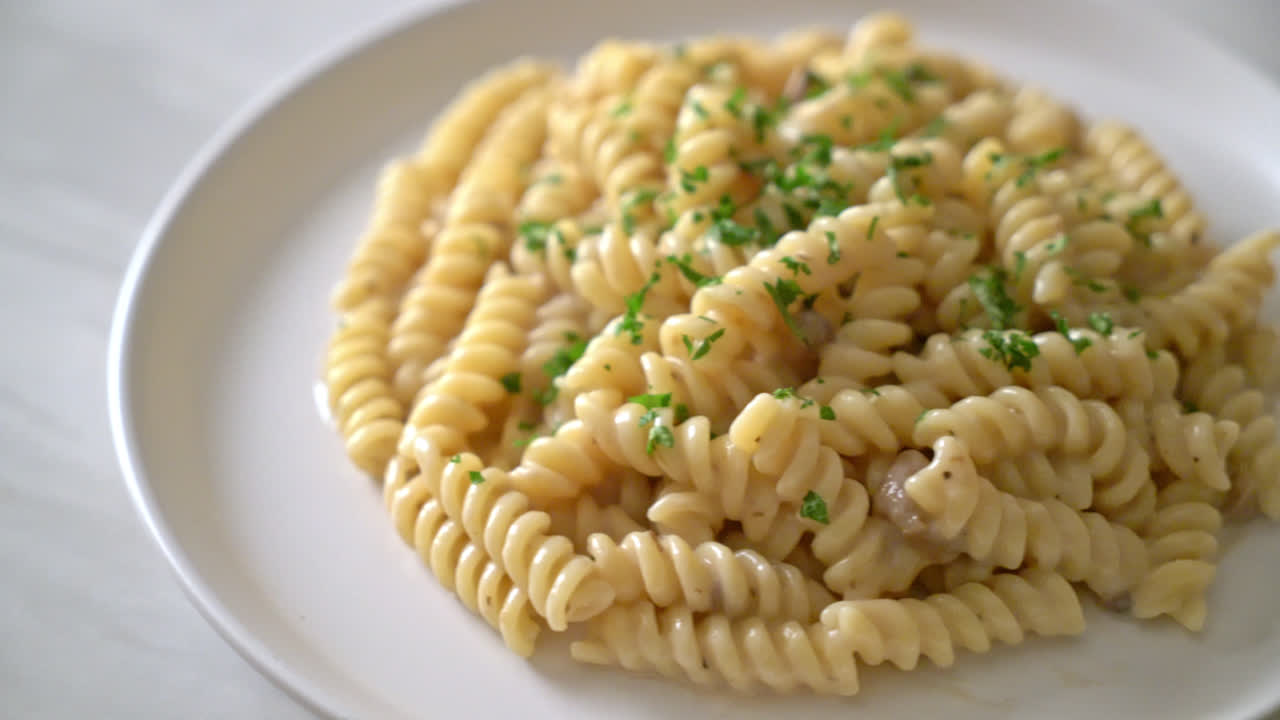 파슬리를 곁들인 스파이럴리 또는 스파이럴 파스타 버섯 크림 소스 - 이탈리아 음식 스타일