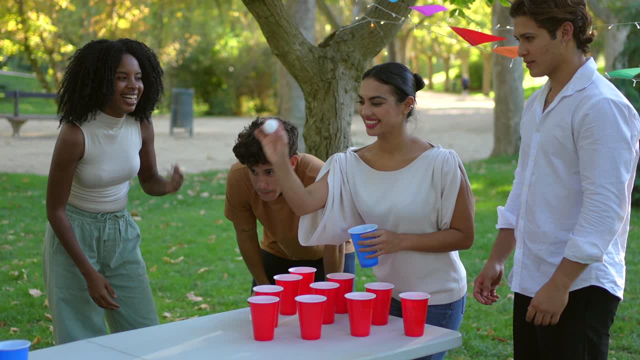Friends playing beer pong at outdoor party