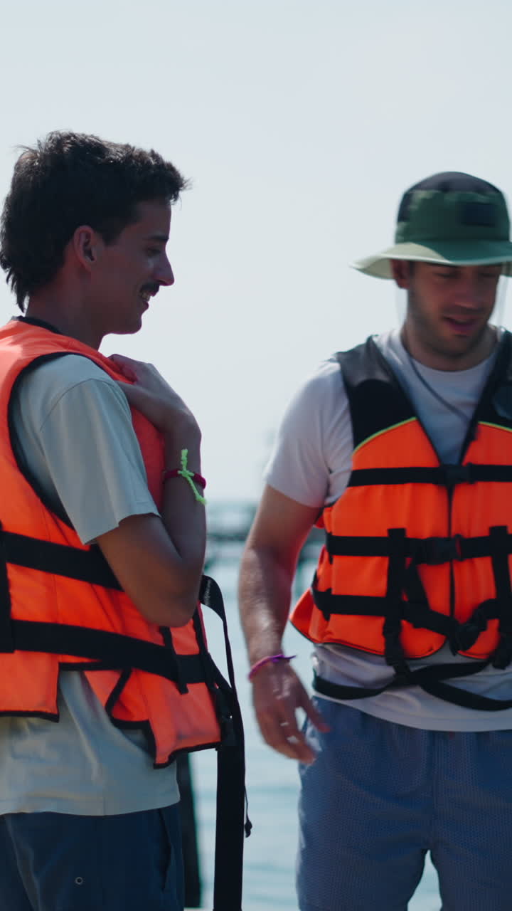 Personas con chalecos salvavidas cerca del mar