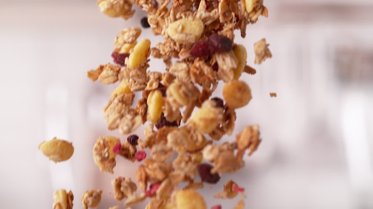 한 그라놀라 시리얼이 상자에서 어져 매크로와 느린 동작으로 떨어집니다.