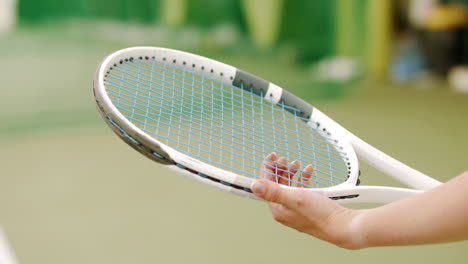 extreme cu caucasian female tennis player adjusting strings on her racket. 120 fps slow motion, 4k uhd raw graded footage