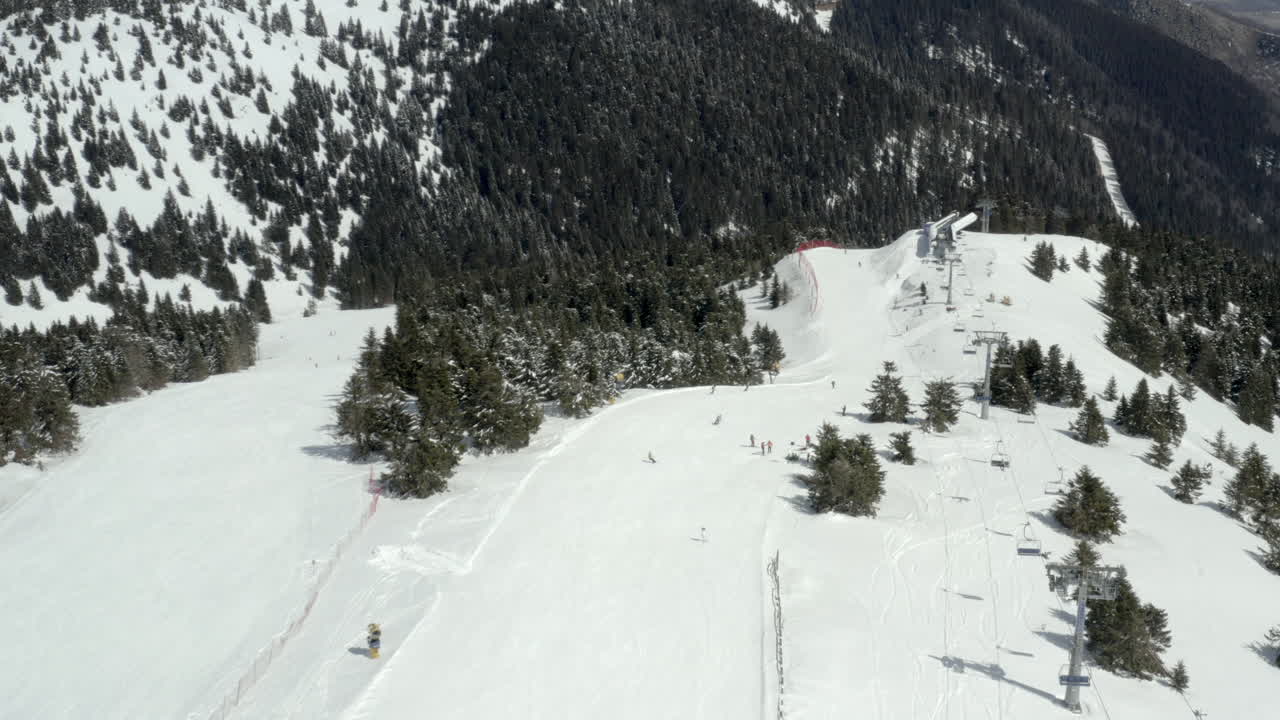 Aerial View of a Ski Resort with Skiers, Snowboarders, and Ski Lifts on a Sunny Winter Day