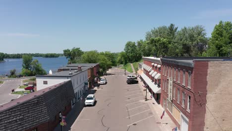 Low-aerial-shot-flying-over-downtown-single-street-Center-City,-Minnesota