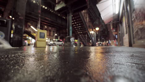 Out-Of-Focus-Dystopian-Street-With-Focus-Rack-on-Asphalt-and-Tilt-Down,-Night
