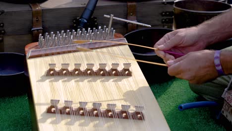 músico tocando un instrumento medieval de dulcimer con pequeños martillos