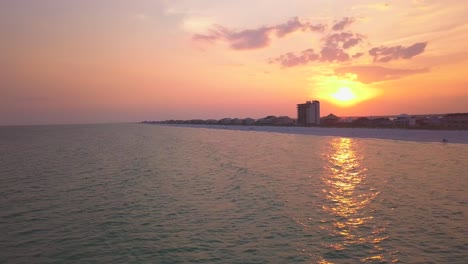 Eine-Langsam-Bewegte-Luftaufnahme-Des-Strandes-Bei-Sonnenuntergang-Mit-Leuchtenden-Farben