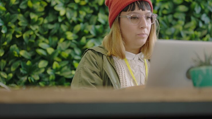 young caucasian business woman student using laptop computer working typing email enjoying lunch break eating food in modern office