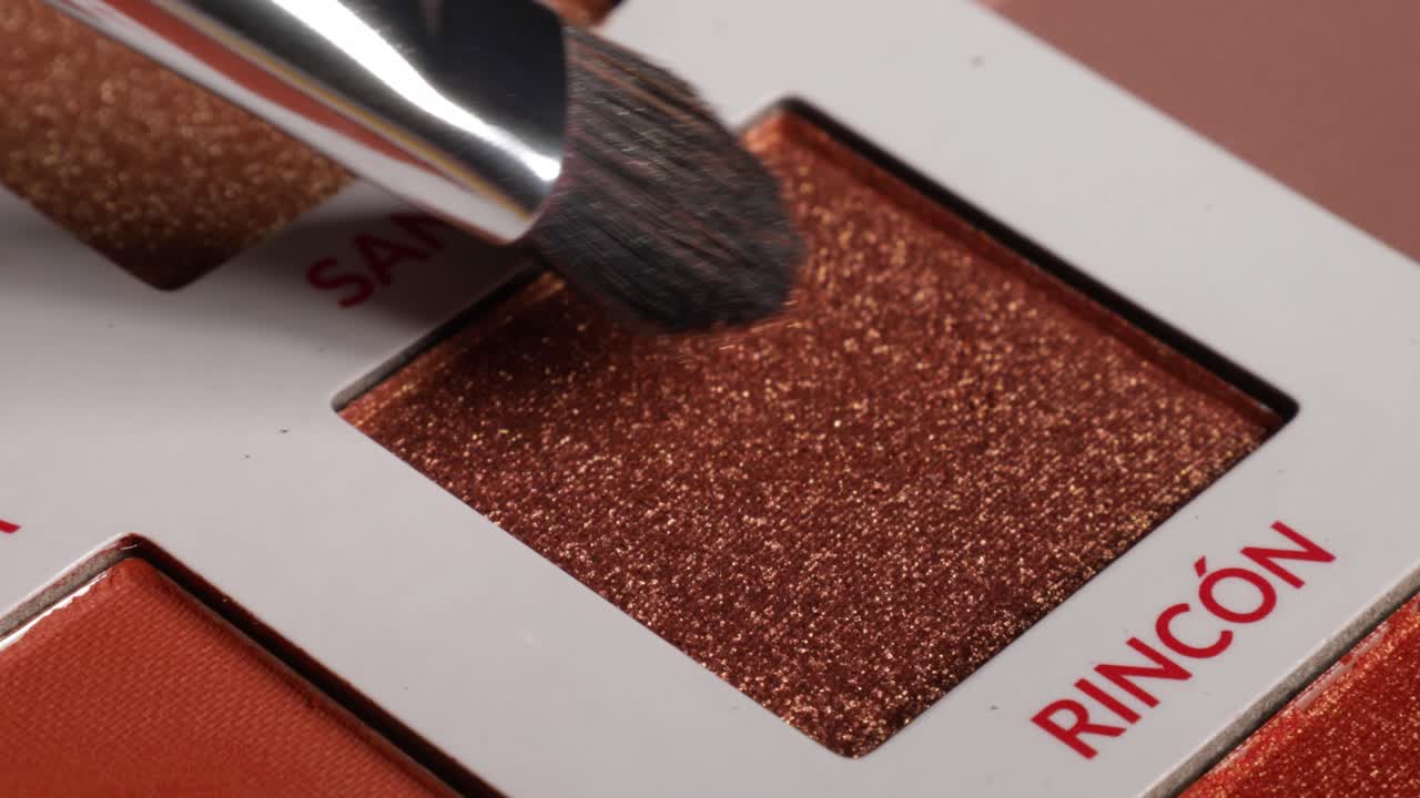 Close up shot of eyeshadow on a palette with makeup brush,