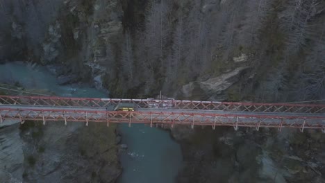 car driving across bridge over a canyon along a four wheel drive track during sunset.