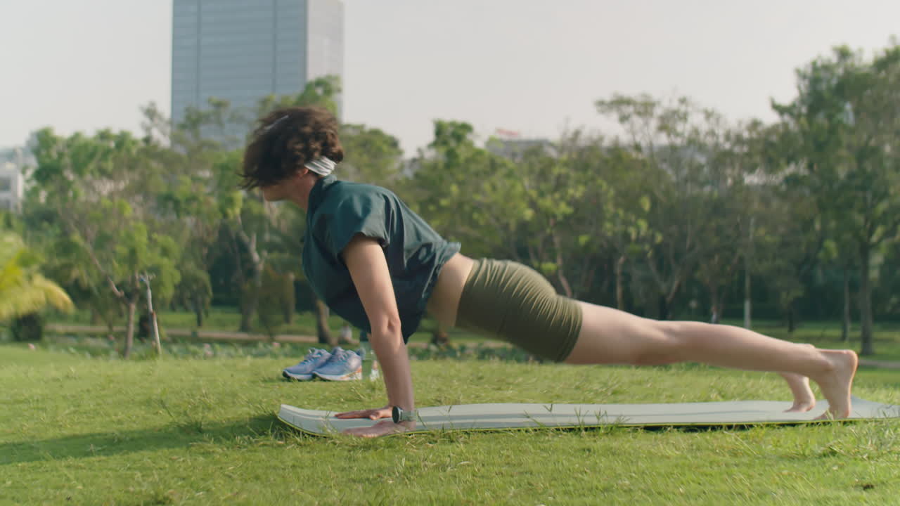 Woman Practicing Vinyasa Yoga Outdoors in Morning