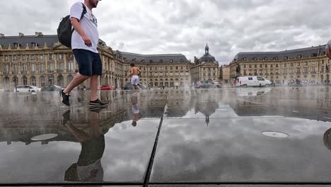 visitors walking on reflective water surface