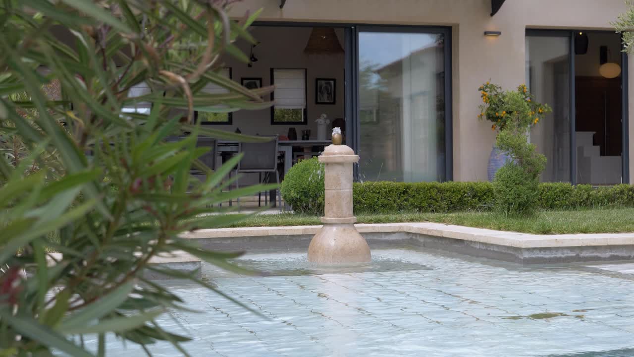 푸른 관목 한가운데에는 수영장이 있는 집이 있고, 작은 폭포가 부드럽게 떨어집니다.