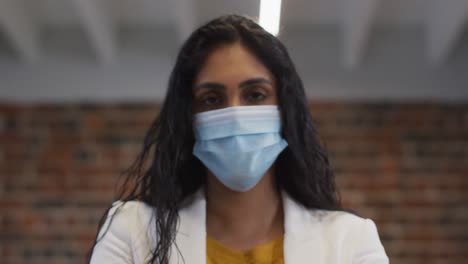 Portrait-of-woman-sanitizing-her-hands-at-office