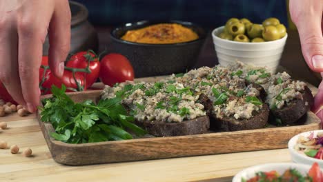 israeli cuisine. forshmak on black rye bread decorated with parsley close-up. national jewish herring dish, middle eastern culture. traditional snack vorschmack made of fish fillet