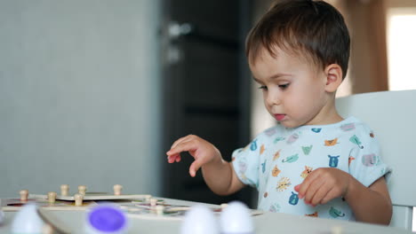 beautiful caucasian toddler playing with toys. child playing a game and speaking. close up. blurred backdrop.