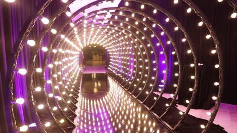 tunnel of light bulbs in a perspective pan view with pink violet colors, abstract copy space