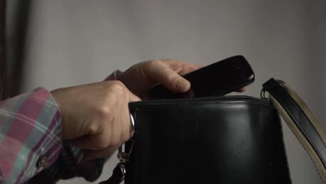 woman getting cellphone out of handbag close up shot