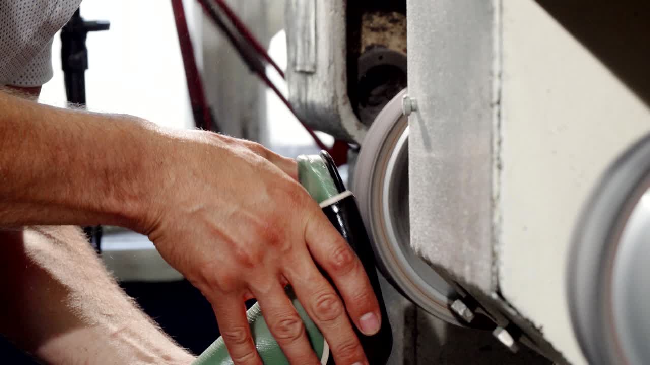 zapatero usando una máquina de moler en su taller