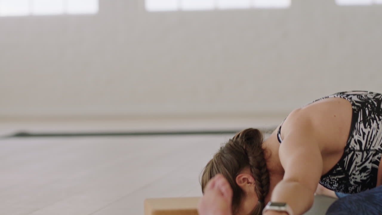 hermosa mujer de yoga ejercitando un estilo de vida saludable practicando una pose de curvatura hacia adelante sentada en gran angular disfrutando del entrenamiento en el estudio ejercicio de respiración consciente