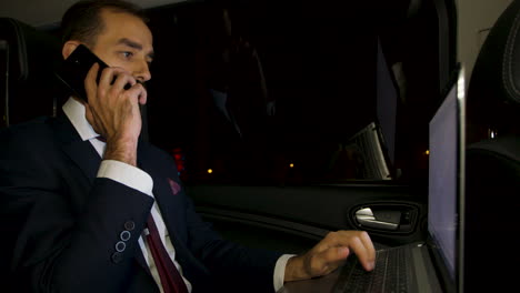 bearded businessman yelling during a phone call in the back seat of his limousine