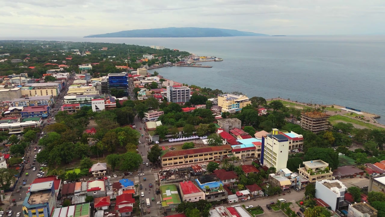 Cinematic drone vista over Dumaguete City, Negros Oriental, capturing the coastline and vibrant city life from above