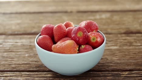 Close-up-of-milk-pouring-in-bowl-of-fresh-strawberries