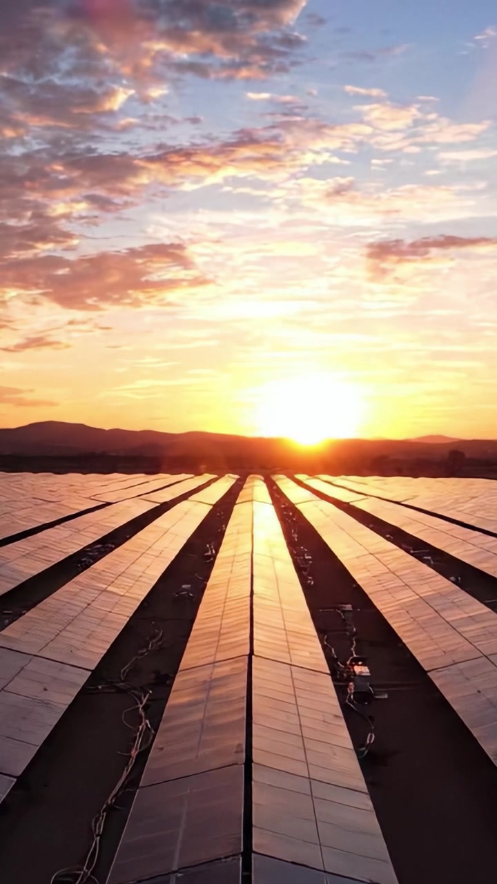 Et Betagende Panorama af Solpaneler, der Strækker sig over Landskabet, Reflekterende den Varme Glød fra en Fantastisk Solnedgang, og Omdanner Bæredygtig Energi til en Levende Horisont