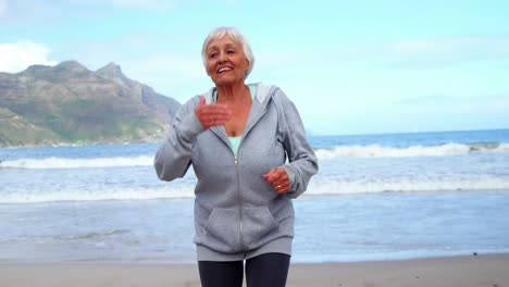 senior woman jogging on the beach