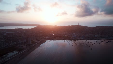 dramatic sunset over city of coquimbo in chile with famous third millennium cross in distance