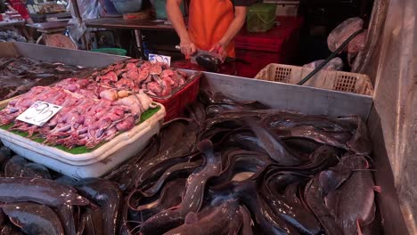 stall worker arranging seafood at a busy market