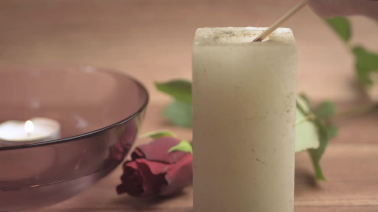 Accendere una candela con una rosa rossa per una serata romantica.