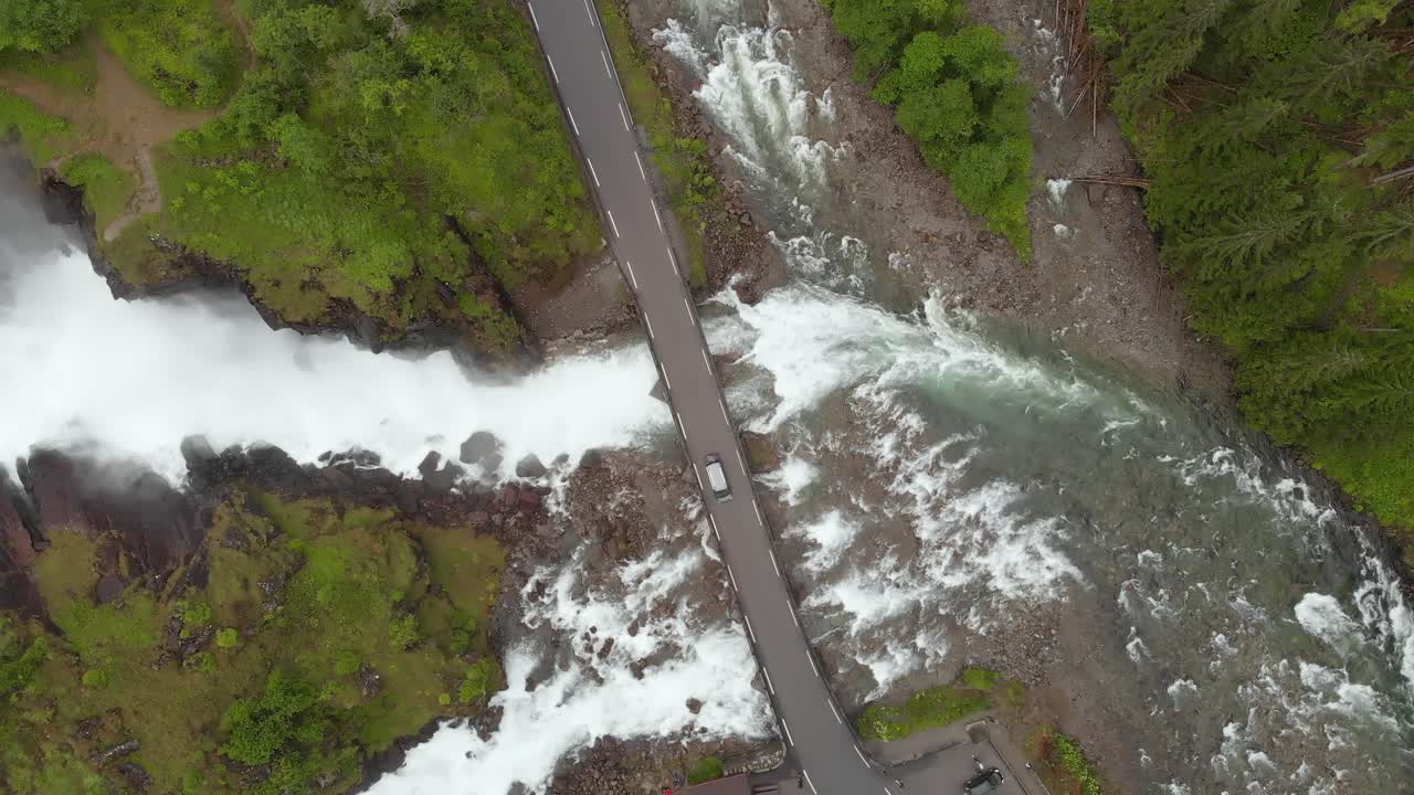 Car crossing Latefossen Waterfall road bridge in Norwegian highlands, aerial
