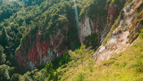 Wide-shot-of-steam-coming-off-Rainbow-Mountain,-Rotorua,-New-Zealand