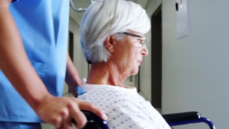 enfermera que lleva a una paciente anciana con silla de ruedas