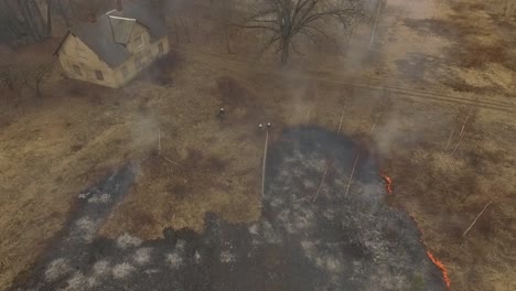 Spring-dry-grass-wild-fire-in-birch-forest-and-firefighters-abandoned-building