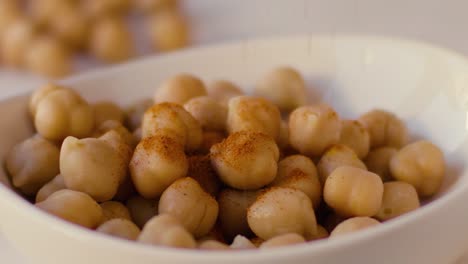 La-Lluvia-De-Curry-Cae-A-Cámara-Lenta-Sobre-Los-Garbanzos-Colocados-En-Un-Tazón-Blanco