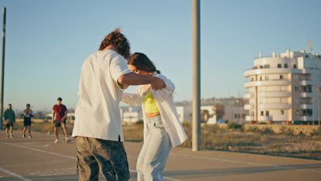 couple dancing and skateboarding in a city park