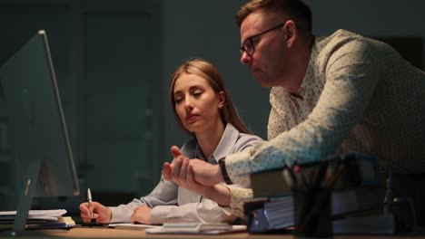 Colleagues Collaborating on a Computer in a Dark Office