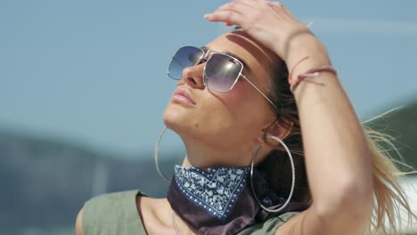 young woman in sunglasses is looking towards the sun