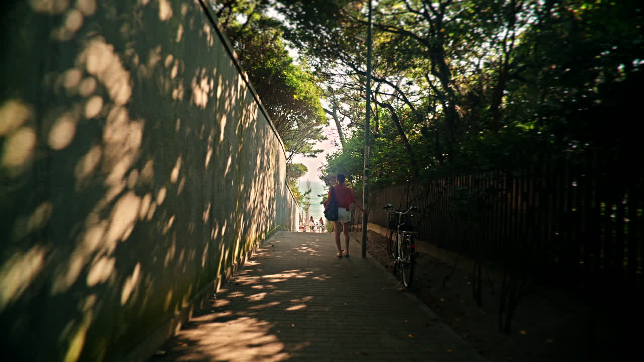 Woman Walking Down a Shaded Pathway